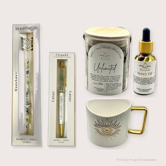 Morning Ritual Luxe Wealth set with the Abundance Manifest Stir, Unlimited Ritual Tea, Fortune pen and Money Oil, shown with the Third Eye mug (sold separately)